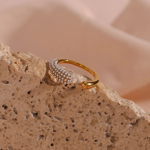 Macro shot of gold open ring with micro-set white pearls on textured stone base