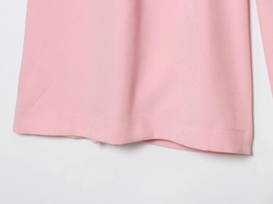 Close-up of pink twill fabric texture and clean stitched hem of the sleeveless top and pants