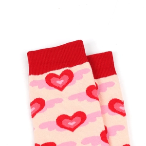 Detail of pink knitted socks with red heart patterns and soft ribbed cuffs