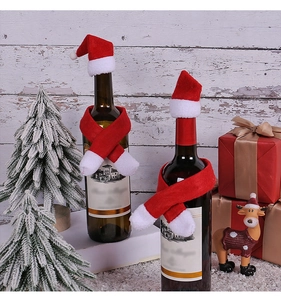 Close-up of mini plush Christmas hats and scarves set on wine bottles in a festive scene