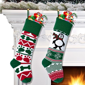 Knitted Christmas stockings with penguin and bone patterns hanging on fireplace mantel