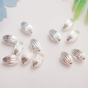 Detailed macro view of silver striped oval beads for DIY bracelet jewelry making