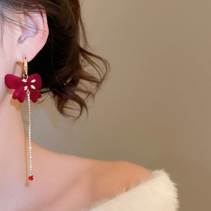 Model wearing red velvet bow tassel earrings with sparkling crystals for elegant look