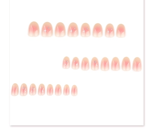 Detail of short round peach gradient press-on nails with white star and silver decor
