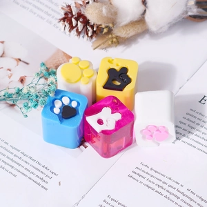 Detailed view of colorful 3D resin cat paw stamps with textured pads on white magazine
