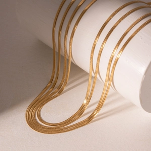 Detailed view of 5mm gold snake chain necklace with flat blade texture and polished finish