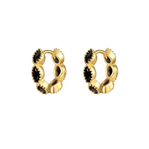 Macro shot of gold hoop earrings featuring multifaceted black stones with high luster