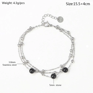 Detail of triple-layer stainless steel chain bracelet with silver beads and black stones