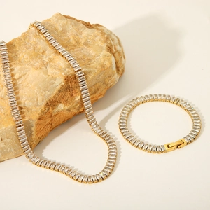 Detailed view of gold-plated zircon necklace and bracelet set on a natural stone base