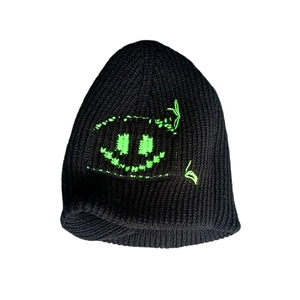 Detail of black knit beanie featuring neon green embroidered smiley face design