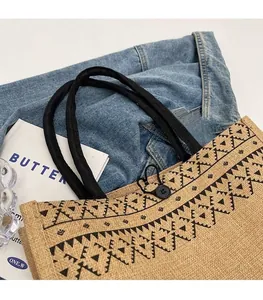 Close-up of linen tote bag with black geometric patterns and woven rope handles