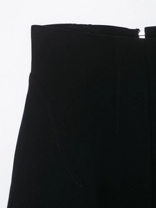 Detailaufnahme der schwarzen High-Waist-Hose mit Metallreißverschluss und geschwungener Naht