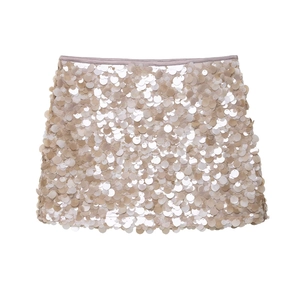 Détail des grandes paillettes dorées champagne et de l'ourlet de la mini-jupe