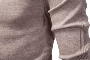 Detail of high-density knit fabric and elastic ribbed seams on light coffee sweater
