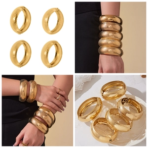 Dettagli di bracciali larghi placcati in oro 18k con texture martellate e spazzolate