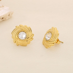 Detailed macro view of gold geometric rhinestone earrings with spiral sunburst texture