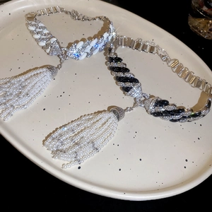Close-up of luxury tassel necklace with white pearls and sparkling crystal chain detail