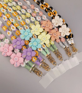 Detailed close-up of colorful handmade braided phone lanyards with smile flower charms
