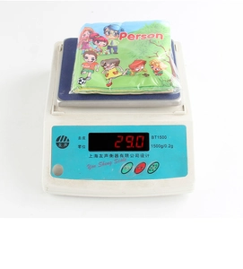 Detailed view of lightweight infant cloth book weighing 29.0 grams on a digital scale