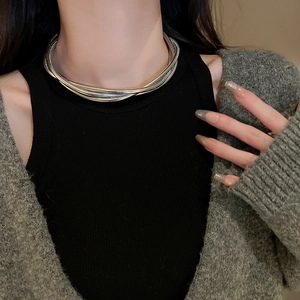 Detail of silver multi-layer twisted chain necklace on model neck with modern design
