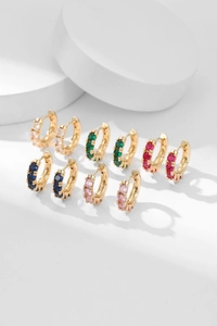 Macro view of gold-plated huggie earrings set with five colorful cubic zirconia stones