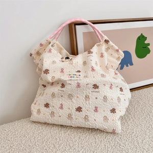 Dettaglio della borsa in seersucker con stampe di animali e manici a quadretti