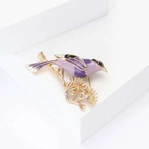 Elegant enamel magpie brooch with pine branch design on gold-tone metal base