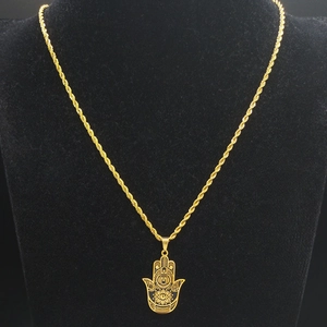 Collier avec pendentif main de Hamsa dorée et œil protecteur sur support noir