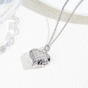 Macro shot of a hollow heart pendant with hammered texture on a silver chain necklace