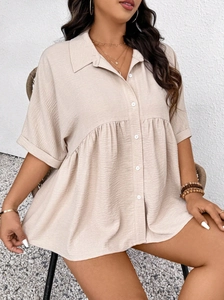 Detail of apricot short-sleeve shirt featuring textured fabric and button-down front
