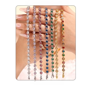 Close-up of hand holding colorful zircon tennis bracelets in gold and silver plating