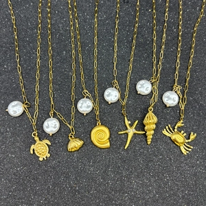 Detailed view of six gold starfish and seashell ocean pendants on stainless steel necklaces
