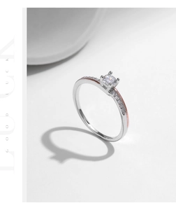 Close-up of silver and rose gold ring featuring a sparkling round center diamond
