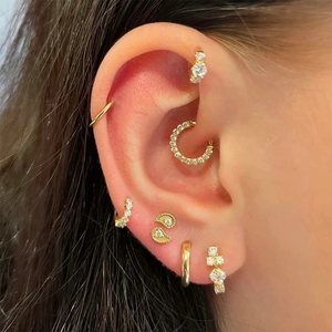 Detail view of gold S925 sterling silver ear cuffs and cartilage hoops with white zircon
