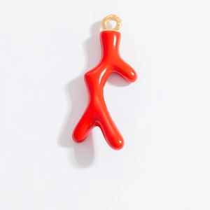 Détail d'un pendentif en corail rouge vif avec un anneau de suspension doré brillant