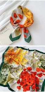Detailed view of silk scarf featuring bright floral prints and dark green border accent