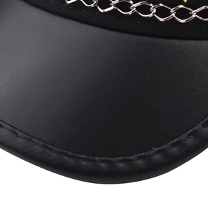 Detail shot of black faux leather military hat featuring a silver metal chain and fine stitching