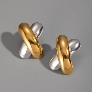Macro shot of polished two-tone 18K gold and silver X-shape crisscross stud earrings