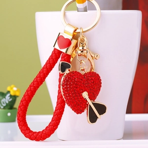 Close-up of sparkling rhinestone heart keychain with red woven strap and gold hardware