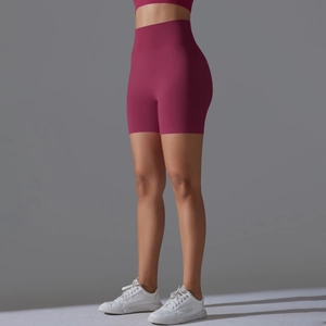 Detail view of burgundy seamless high-waist yoga shorts with wide ribbed waistband support