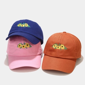 Three cotton baseball caps with sunflower embroidery in blue, pink, and orange