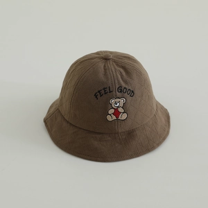 Detail view of the feel good bear embroidery on the brown quilted cotton bucket hat