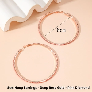 Detail of 8cm rose gold hoop earrings with pink zircons on beige background