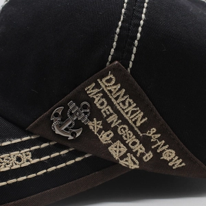 Detail of anchor metal charm and white stitching on heavy cotton canvas baseball cap