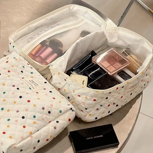 Close-up of quilted cotton makeup bag with colorful polka dots and internal mesh zipper pocket