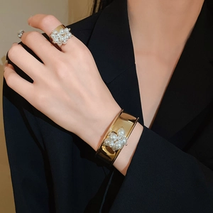 Detail showing gold plated pearl cluster wide ring and cuff bracelet set on model