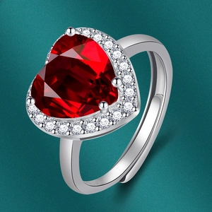 Gros plan d'une bague en zircon rouge en forme de cœur avec cristaux et anneau argent