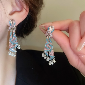 Macro shot of long fringe earrings featuring pink and blue rhinestones with waterdrop crystals