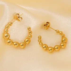 Polished 18K gold-plated stainless steel C-shaped beaded earrings on silk background