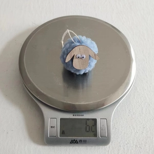 Detailed view of sky blue felt sheep pendant weighing 6.2g on a digital scale